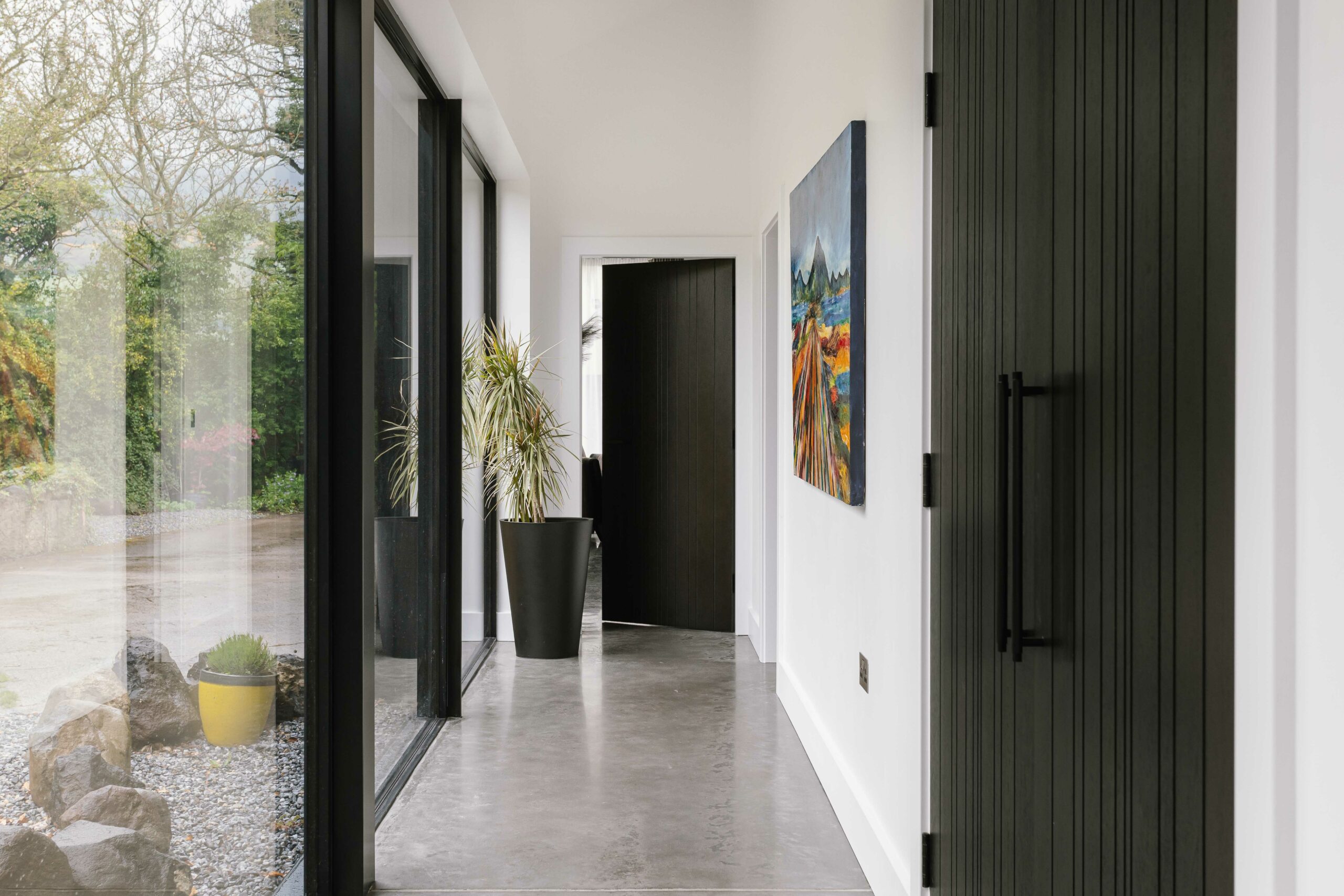 Hallway with left hand glass side and doors leading off to the right